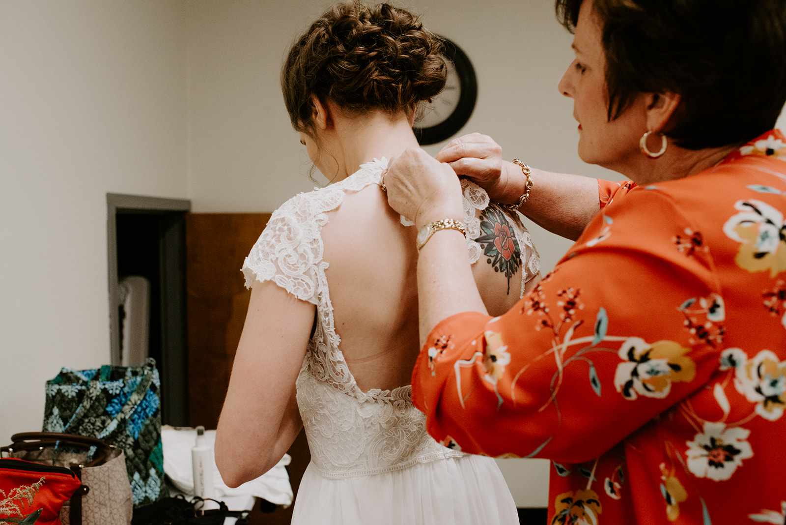 Mother of the bride helps her fasten her bridal gown from Bianka Bridal in Grand Rapids Michigan