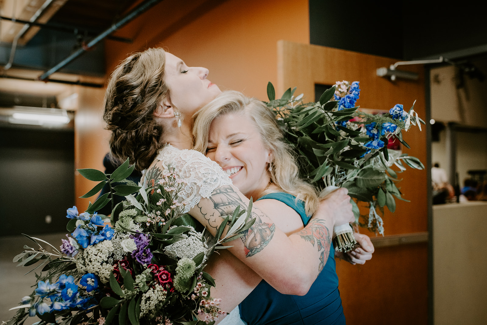 Bride and maid of honor embrace at end of wedding ceremony in Grand Rapids Michigan