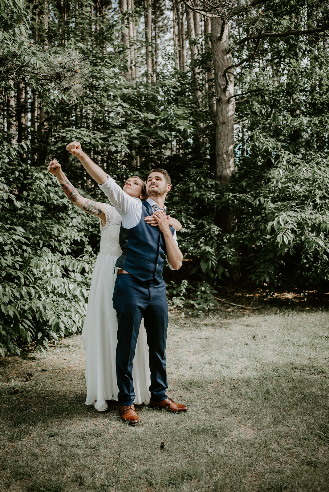 Two MArriers on in a wedding dress from Bianka Bridal in the woods with tall pines 