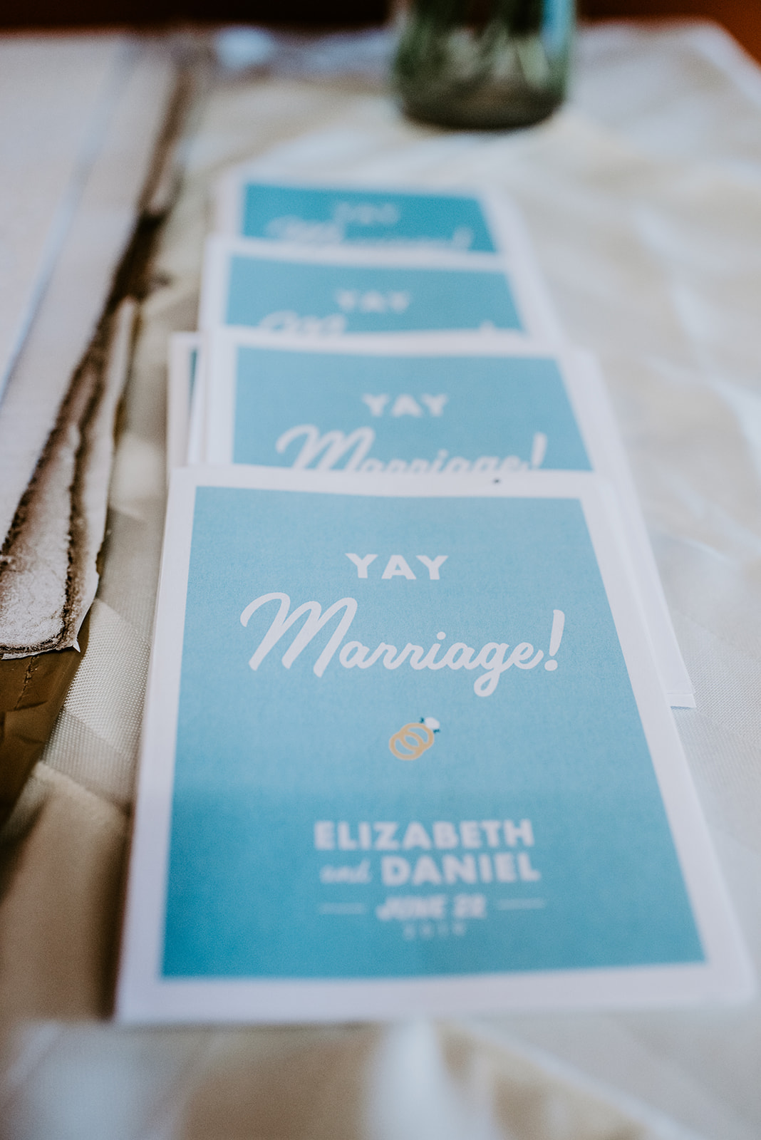Elizabeth and Dan's wedding programs teal blue with Yay Marriage written on it