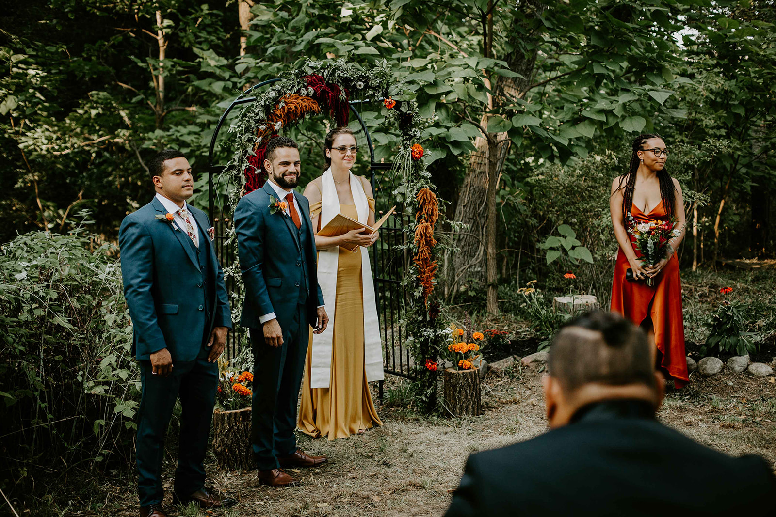 groom at altar. Red, Orange and white flowers. Outdoor wedding. intimate wedding photography. michigan photographer. 