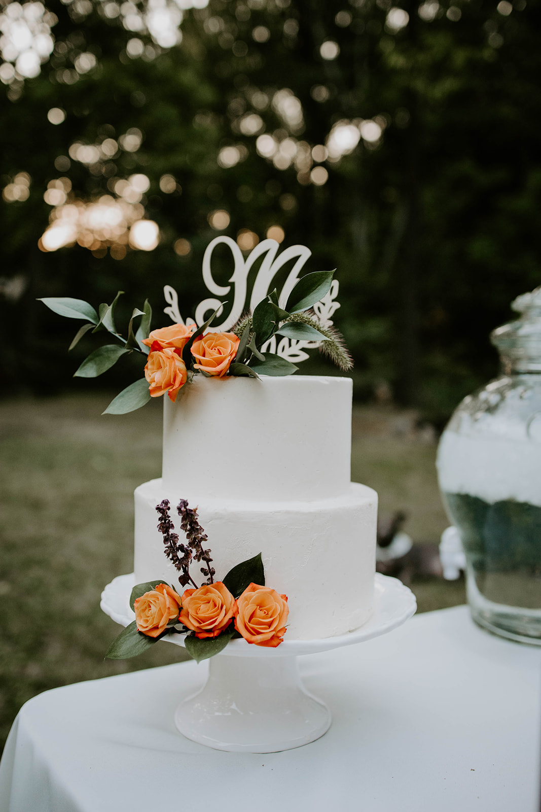 White wedding cake with orange flowers. Outdoor wedding. intimate wedding photography. Michigan photographer. 