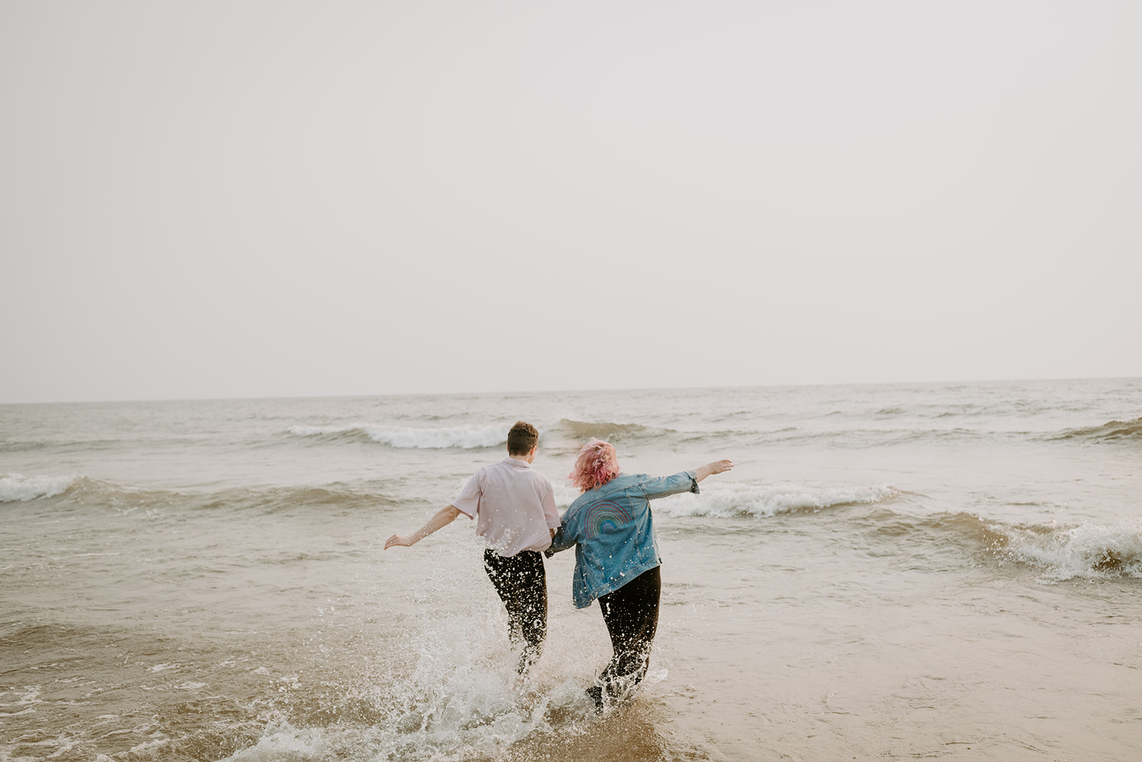 running into the ocean, engagement session, Grand Haven City Beach, beach session