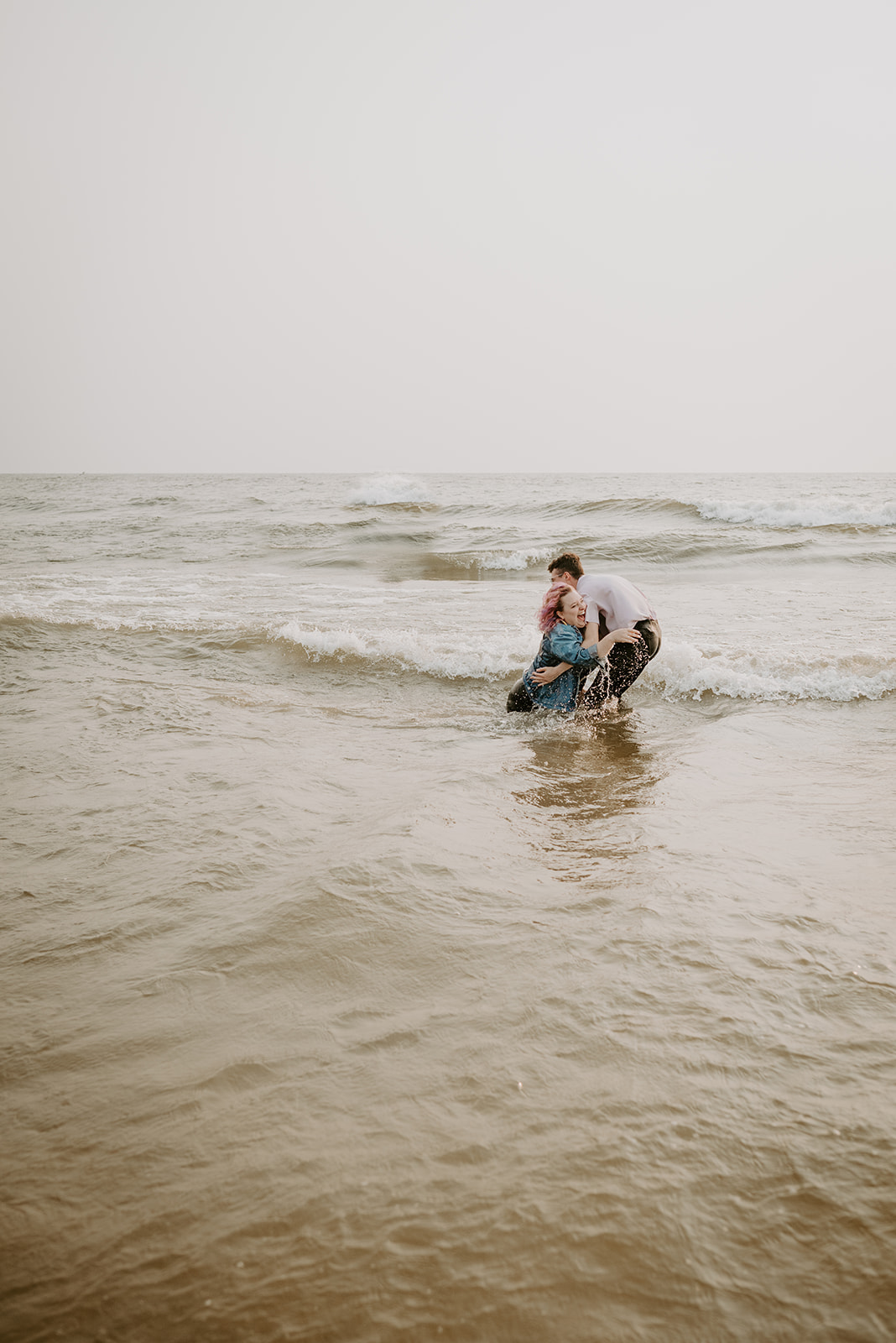 splashing in the ocean, engagement session, Michigan, Grand Haven City Beach