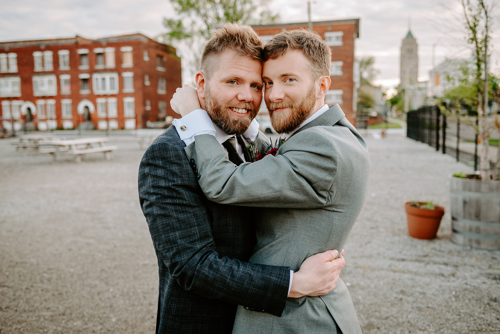 two grooms embracing during formal portraits outside of chroma detroit in michigan an elegant black tie wedding captured by Liv Lyszyk Photography a queer wedding photographer based out of Grand Rapids Michigan