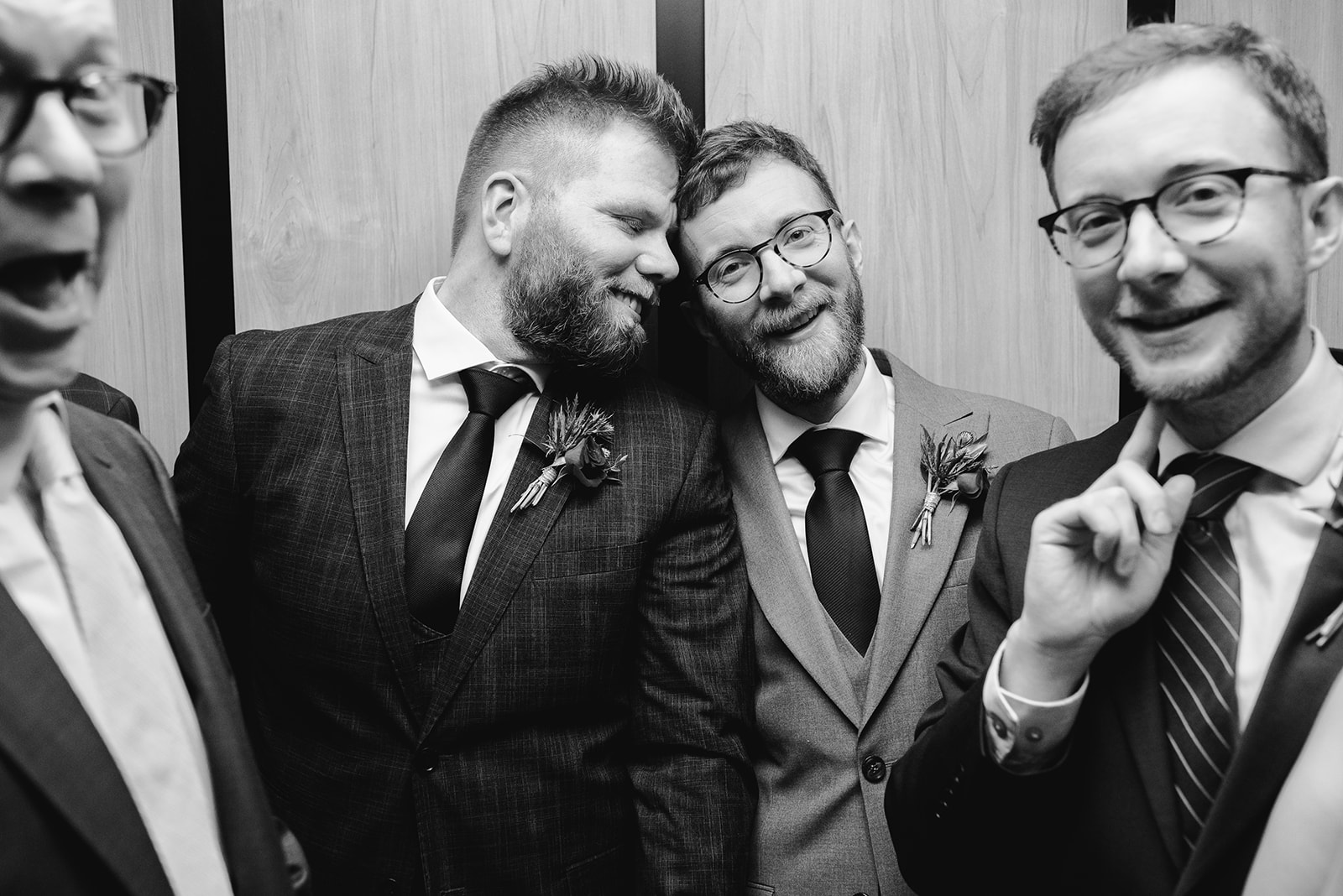 two gay grooms in the elevator after their ceremony at chroma detroit in michigan an elegant black tie wedding captured by Liv Lyszyk Photography a queer wedding photographer based out of Grand Rapids Michigan