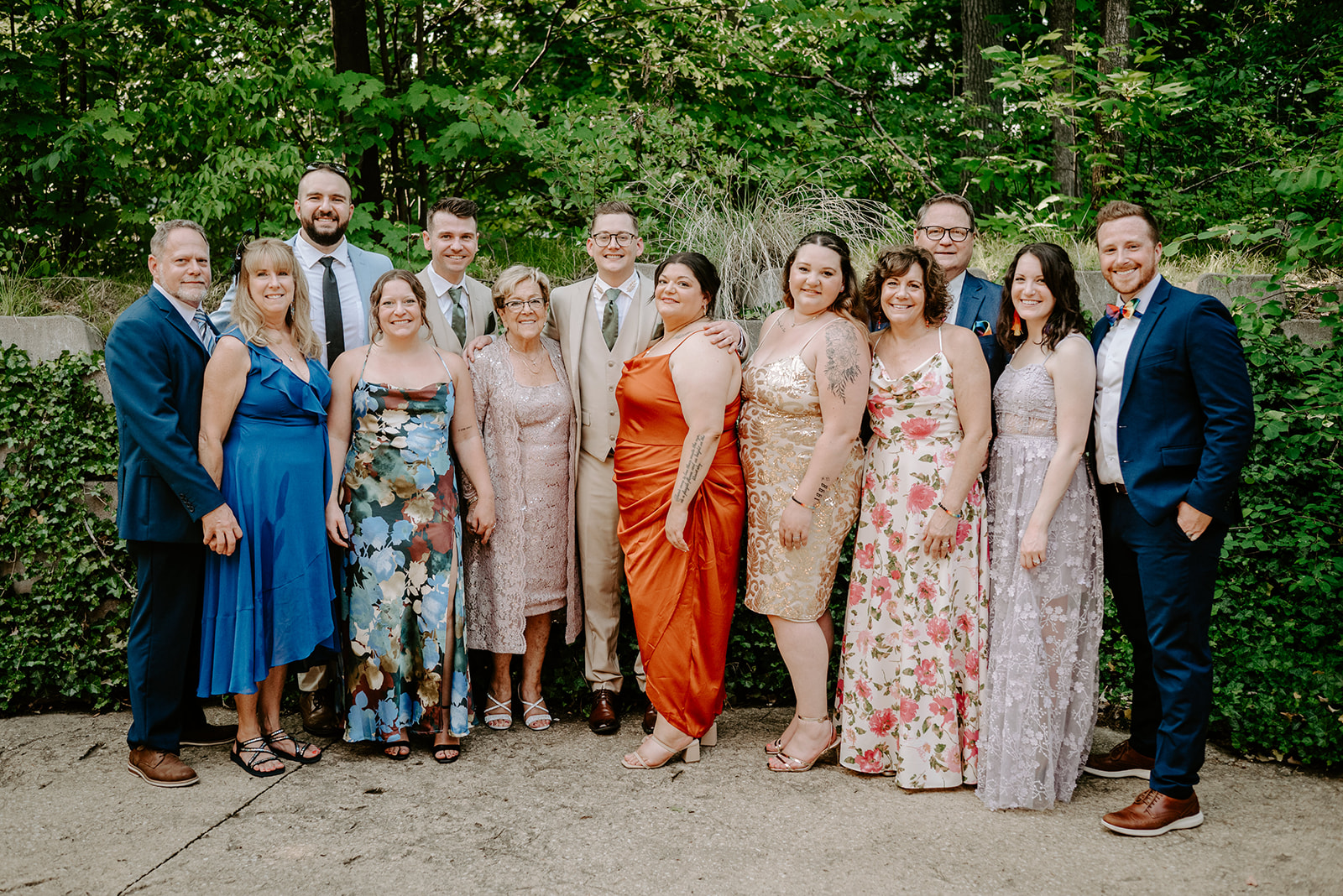 lgbt boho neutral wedding at john ball zoo in grand rapids michigan two grooms in tan suits with green accents in family photo