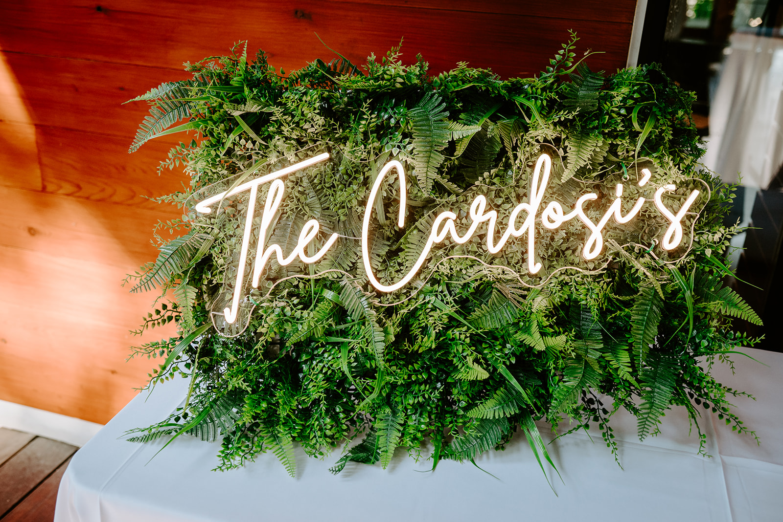 lgbt boho neutral wedding at john ball zoo in grand rapids michigan detail photo of ivy sign with white neon lettering of the two grooms last name