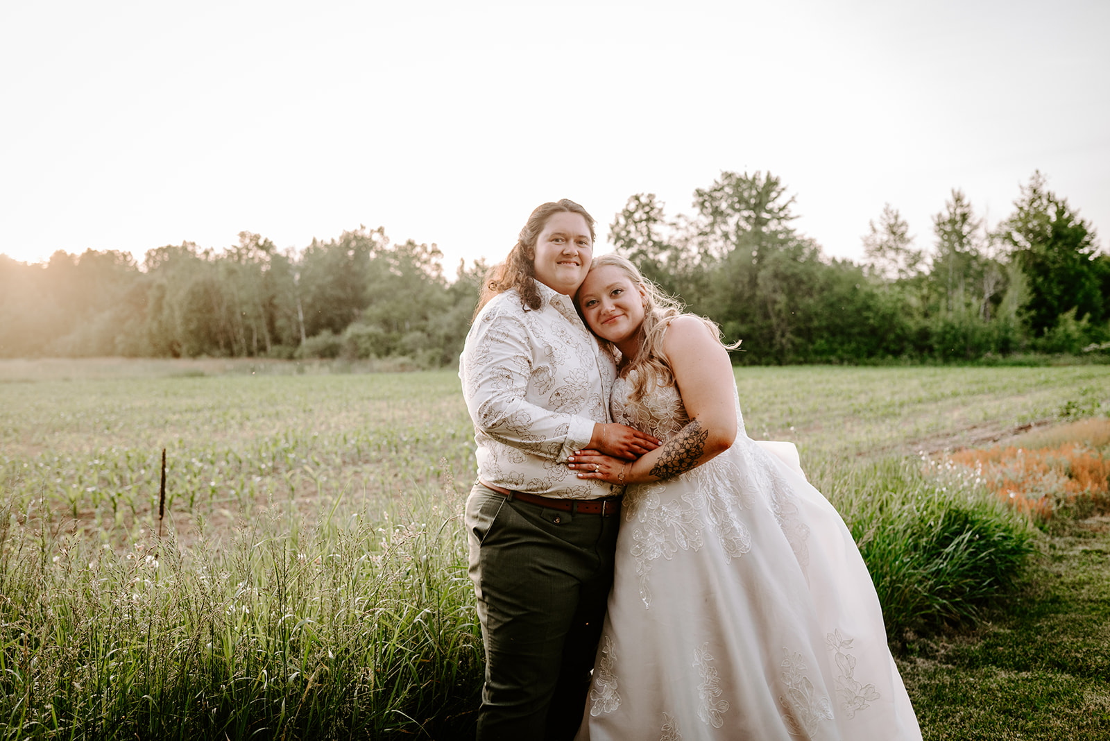 michigan spring DIY lesbian wedding at black sheep shelter sunset golden hour photo of two brides in field