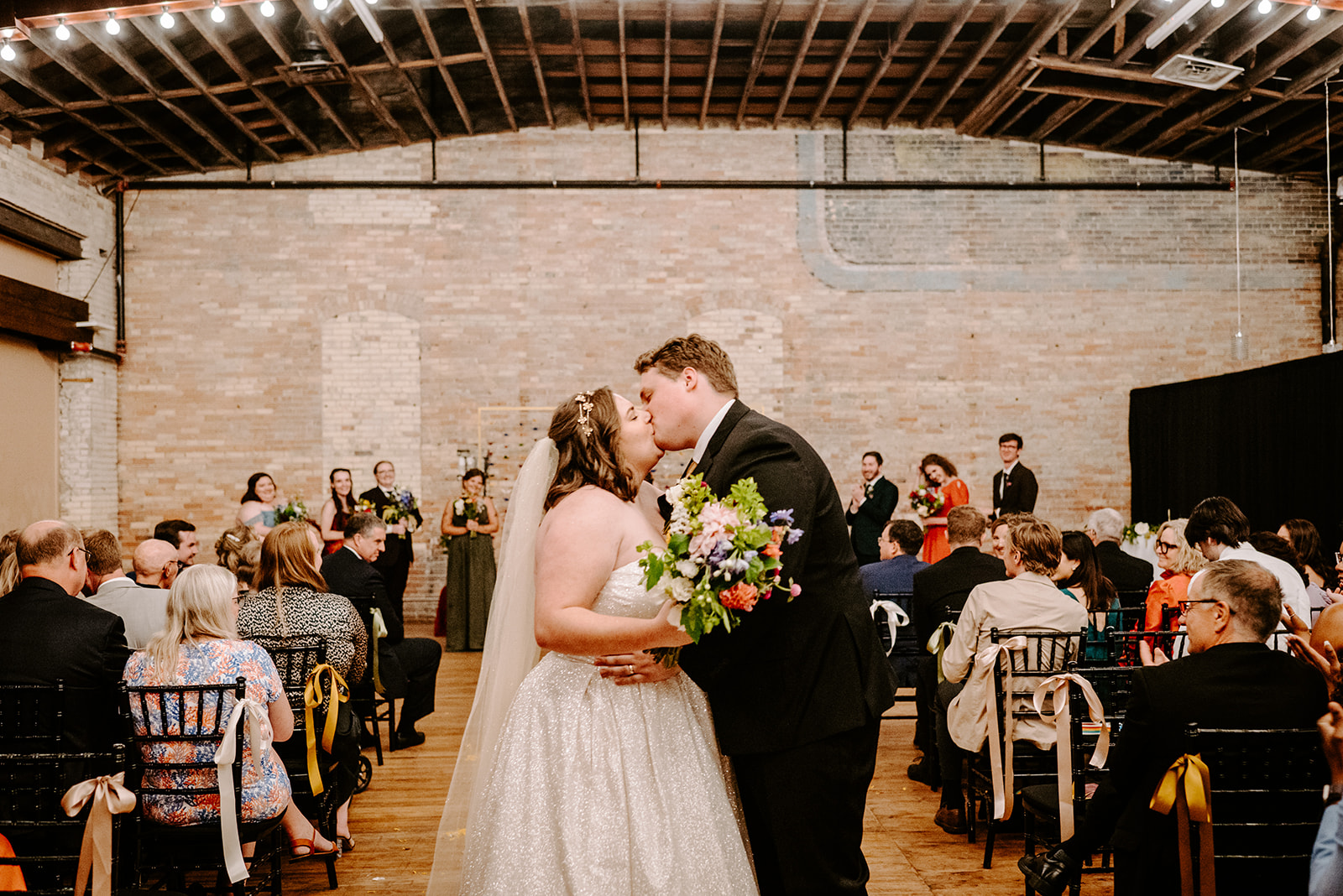 bride and groom kissing at the end of their ceremony at a colorful downtown grand rapids michigan wedding 