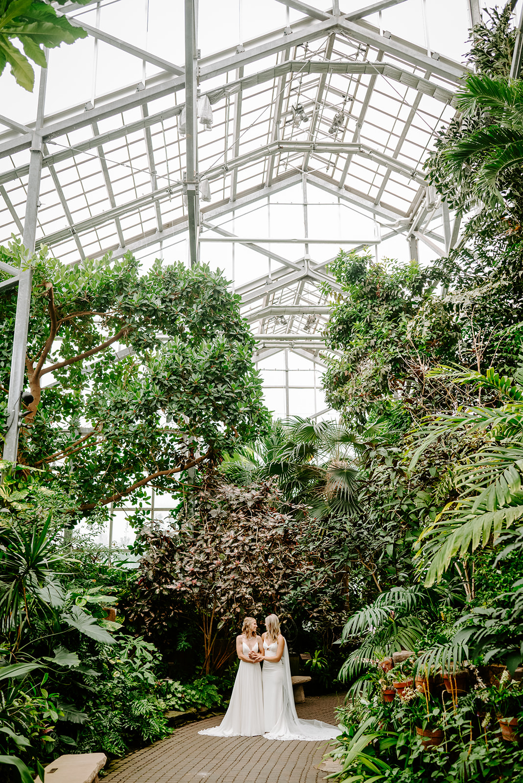 two brides getting married at Meijer gardens at a Grand Rapids LGBT Garden wedding in the greenhouse during portraits