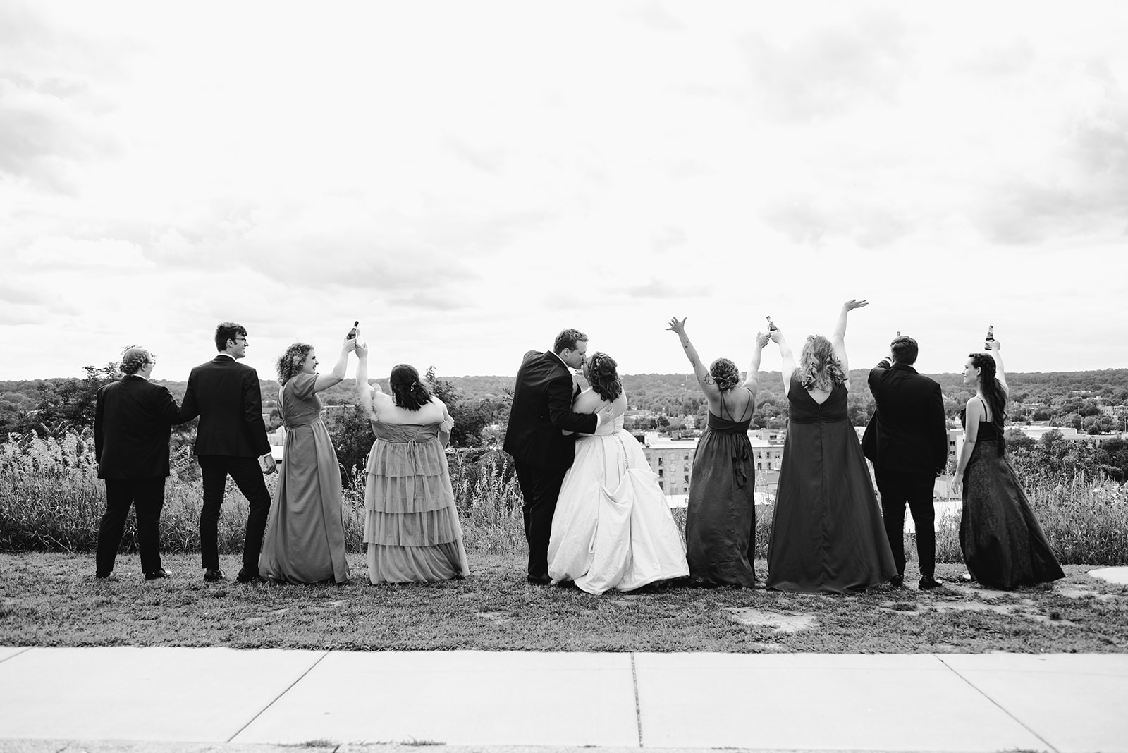 black and white photo of bride and groom with their wedding party celebrating after their downtown wedding in grand rapids michigan