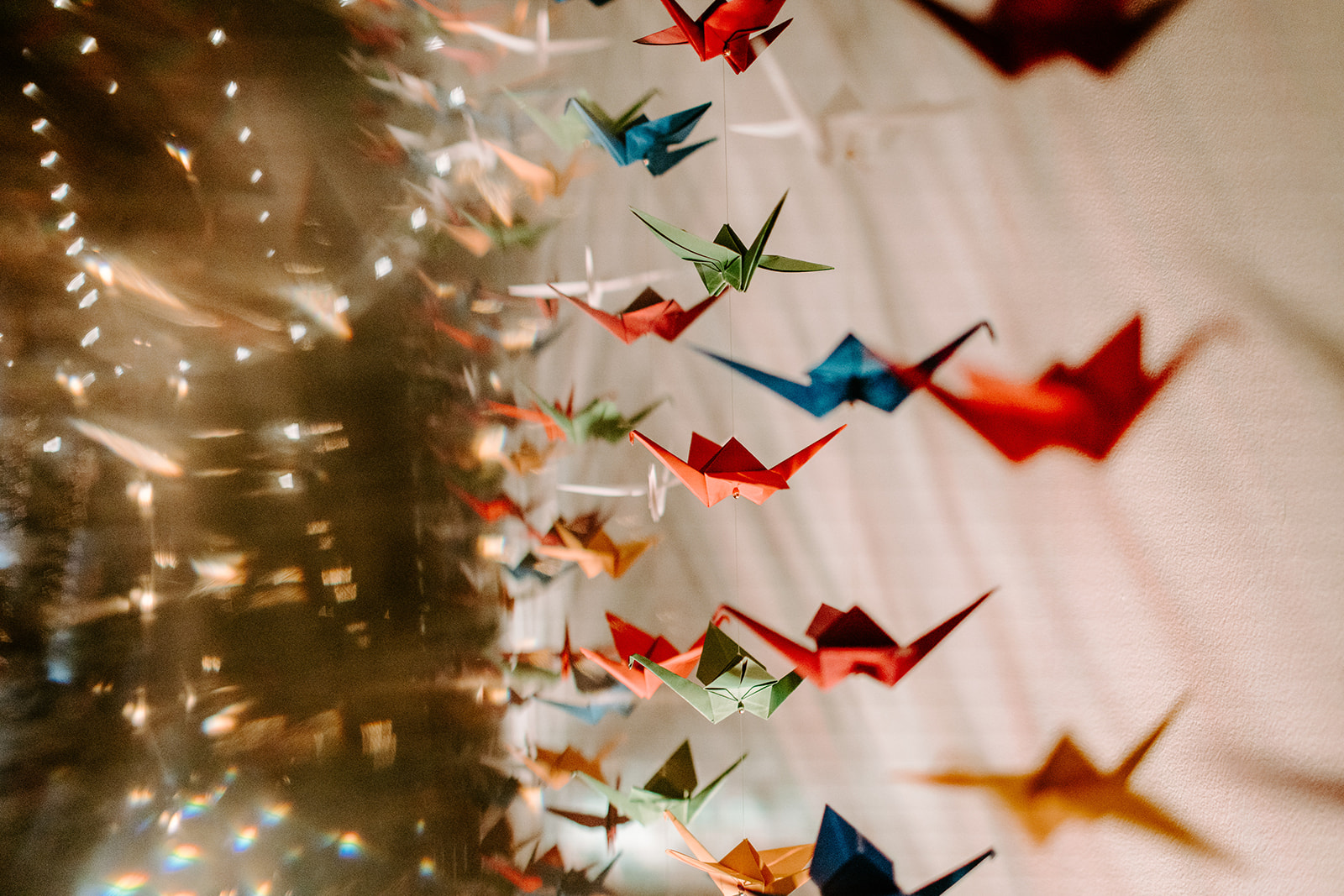 up close detail photo of multi colored paper cranes and twinkle lights at a colorful downtown grand rapids michigan wedding 