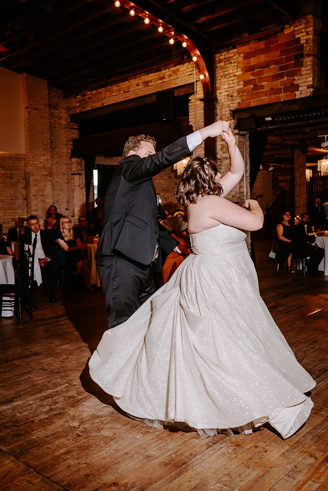 bride and groom twirling during their first dance at a colorful downtown grand rapids michigan wedding 