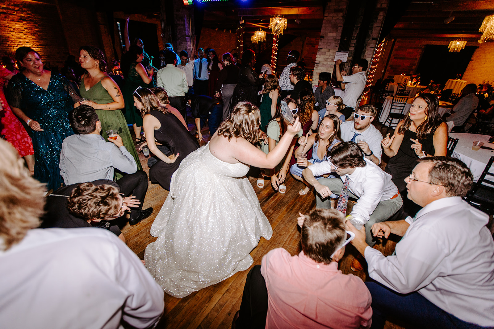 wide angle shot of bride and many guests on the dance floor at a colorful downtown grand rapids michigan wedding 