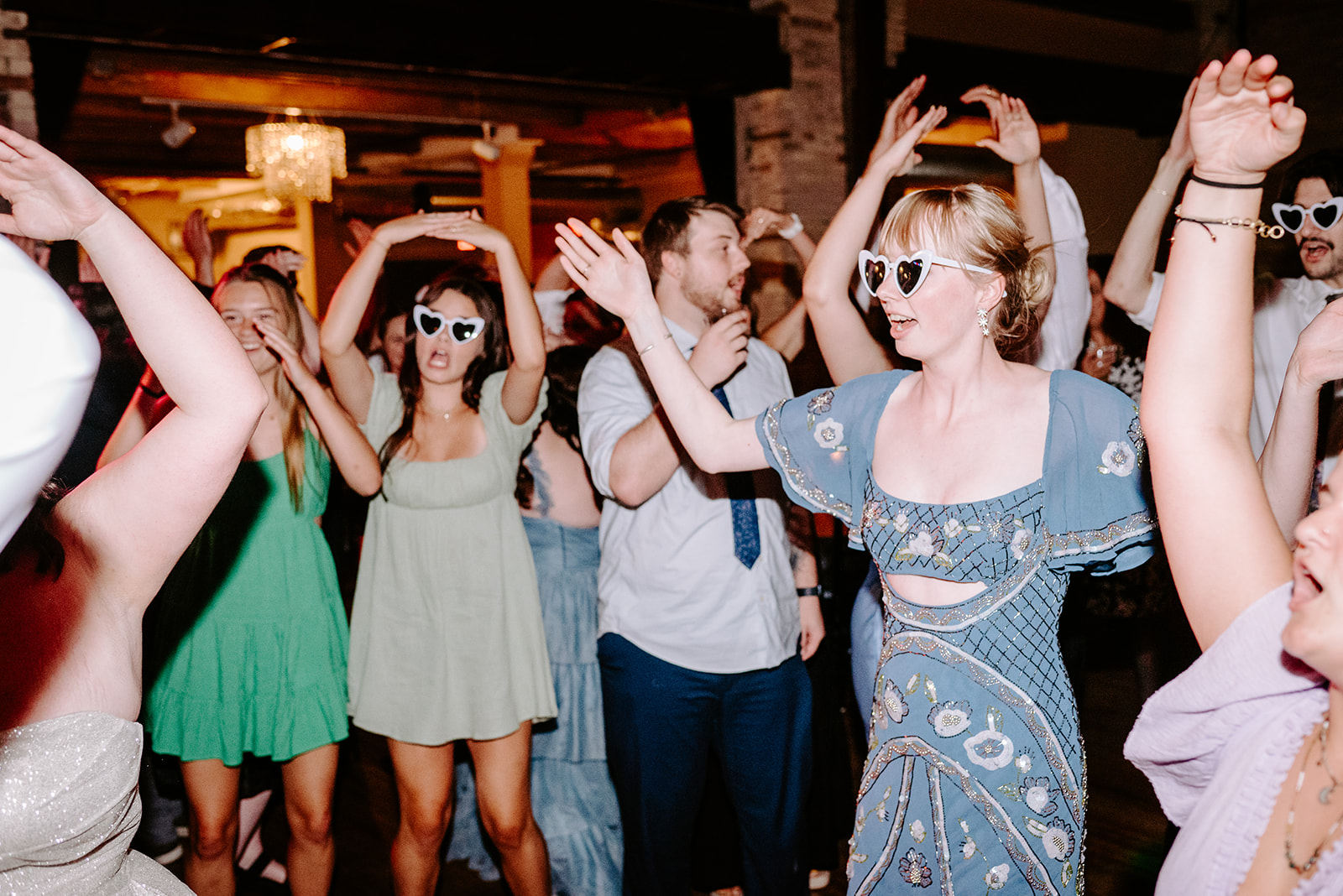 guests at a downtown grand rapids wedding with sunglasses on dancing on the dancefloor