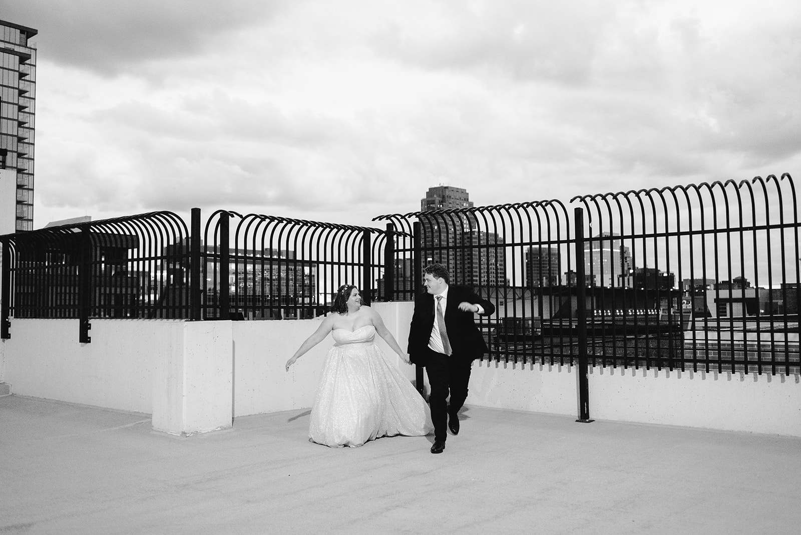 wide angle black and white photo of bride and groom on top of a parking garage in downtown grand rapids michigan on their wedding day