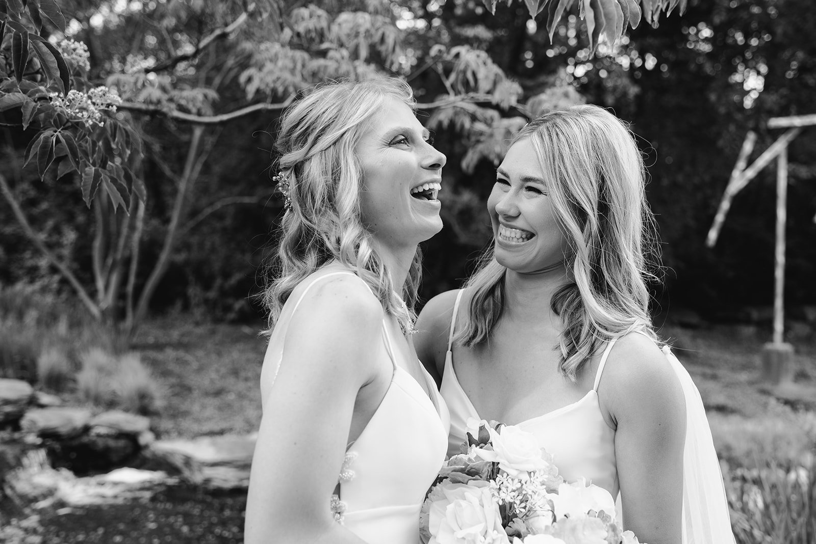two brides getting married at Meijer gardens at a Grand Rapids LGBT Garden wedding during their emotional first look a black and white photo
