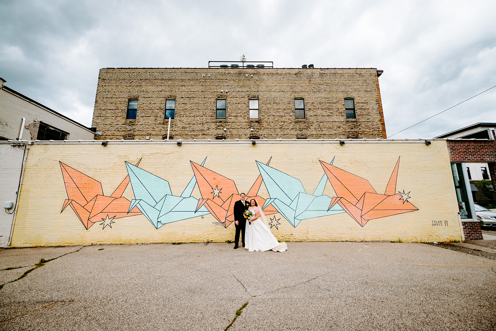 bride and groom in front of mural in downtown grand rapids during portraits at a colorful downtown grand rapids michigan wedding 