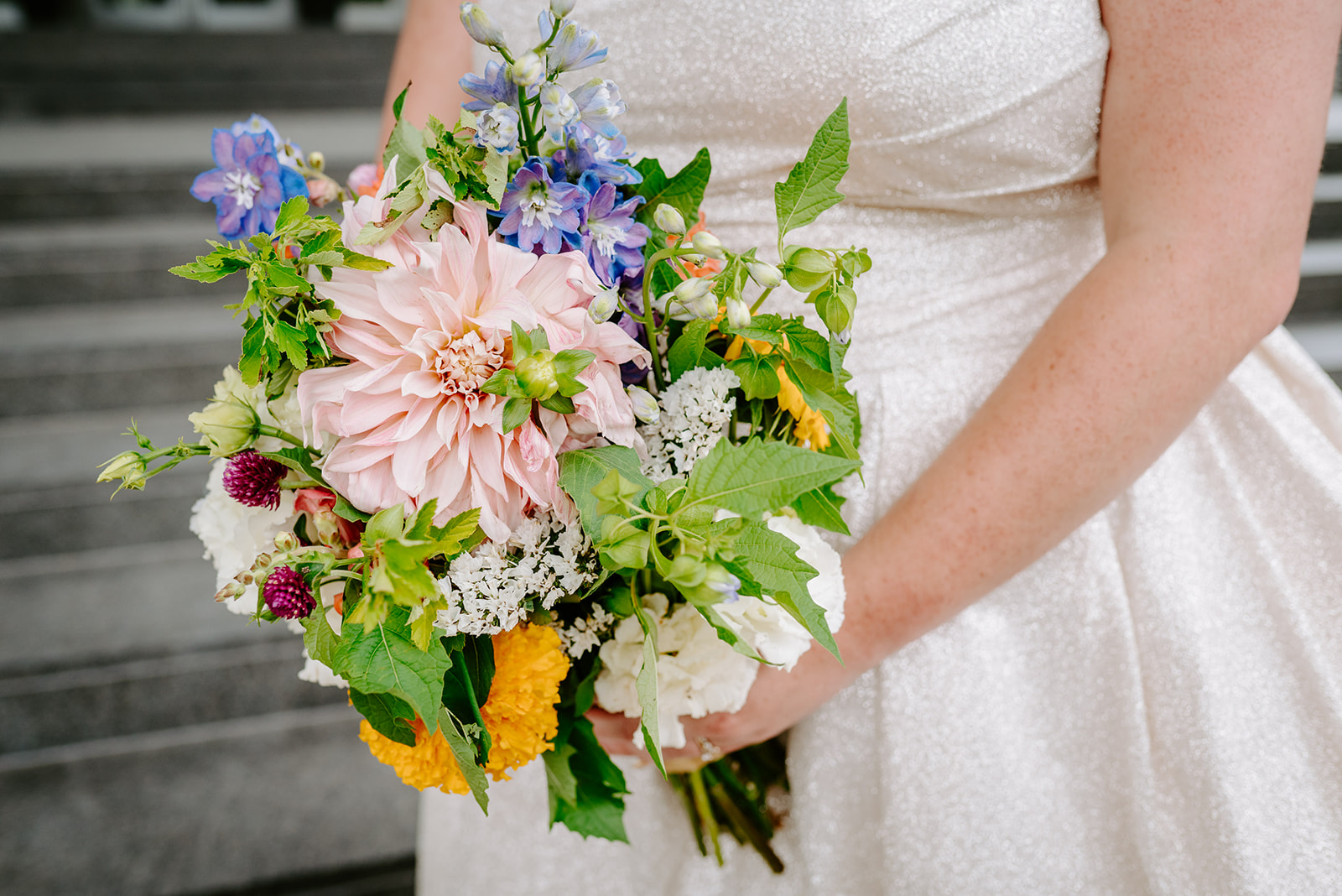 bride holding whimsical wildflower bouquet at a colorful downtown grand rapids michigan wedding 