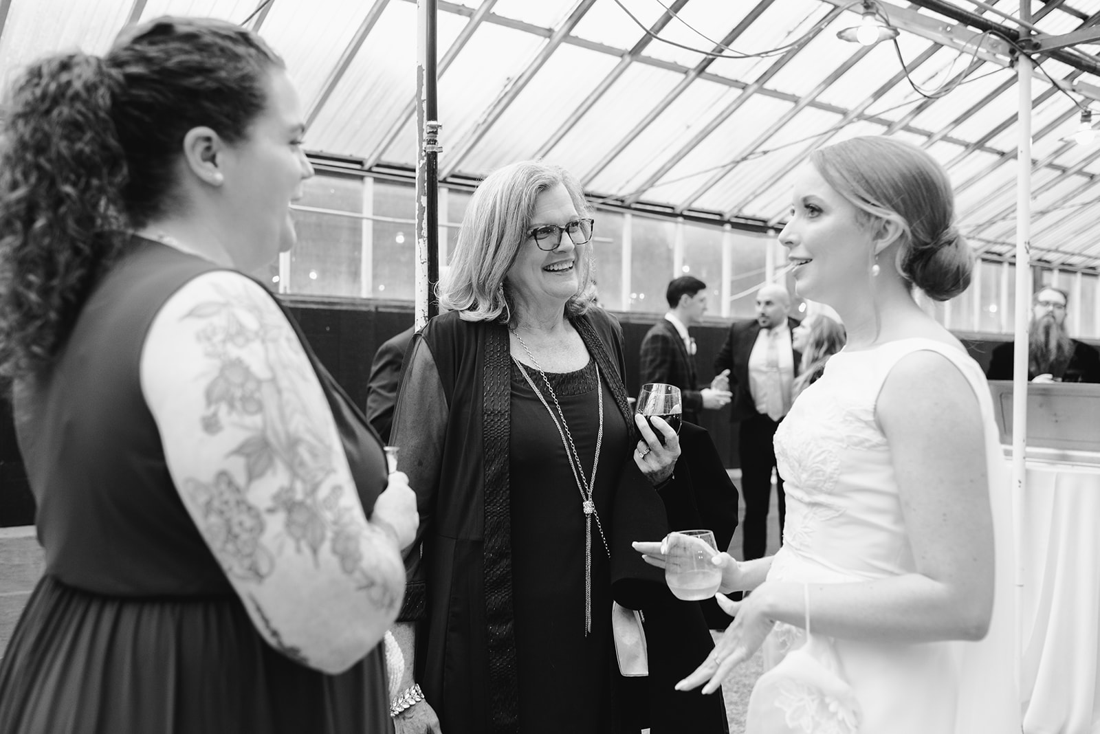 bride mingling with guests at cocktail hour at greenhouse wedding at goldner walsh greenhouse in pontiac michigan by grand rapids and west michigan wedding photographer Liv Lyszyk Photography