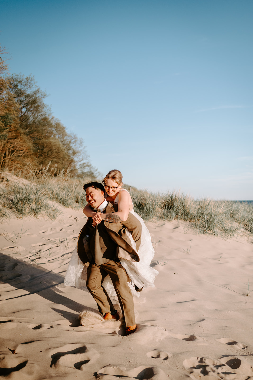 bride and groom on beach at pj hoffmaster state park chinese american elopement photographed by Grand Rapids multicultural wedding photographer Liv Lyszyk Photographer